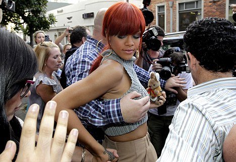 Looks like the best job in the world: Up close and personal: Rihanna's burly bodyguard looks like he was taking his job just a little too literally as he tried to usher the star through crowds to a waiting car
